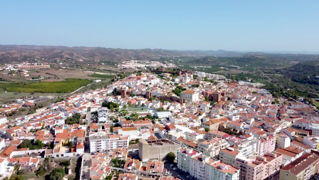 Aerial perspective of Silves City. Situated in South of Portugal, in Algarve Region. Panoramic view of the city with church and castle in top of the hill. Drone truck right and ascending