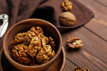 Bowl of walnut kernels on wooden table, closeup