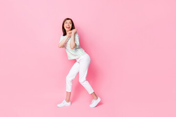 Fototapeta na wymiar Photo of pretty cute lady person dressed trendy striped clothes arms pull hold carry empty space isolated on pink color background