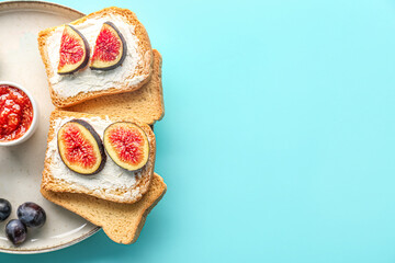 Plate of tasty bruschettas with cream cheese and figs on color background