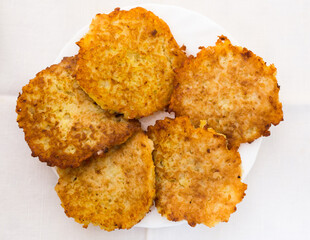Fried grated potato pancakes with sour cream on white plate. top of view