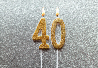 Gold number 40 fourty birthday candle flame on glittering background