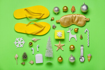 Travel accessories with Christmas decor on green background
