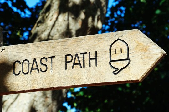A wooden coast path sign in a wooded area of the town, Sidmouth, Devon, UK, Europe