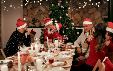 Family, generations and Christmas dinner party with men, women and children smile, eat and drink...