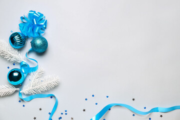 Composition with beautiful Christmas decorations and fir branches on light background