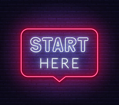 Start Here neon sign in the speech bubble on brick wall background.