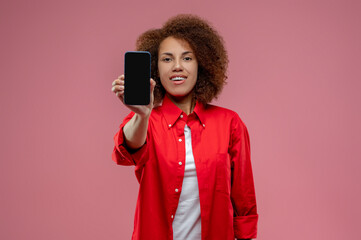 Young curly-haired woman with a smartphone in hands