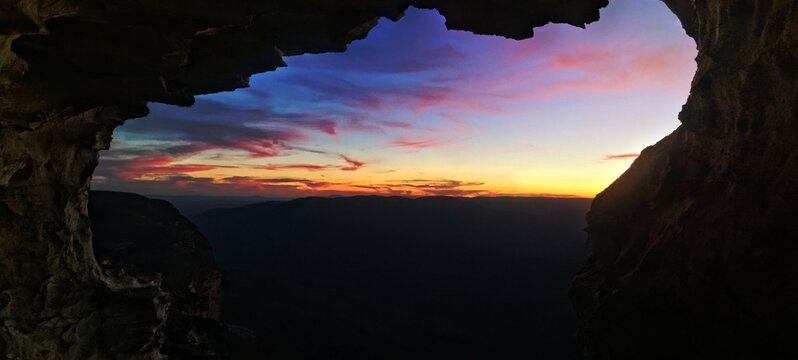 Mountain views to sunset from inside cliff cave © Diaconescu