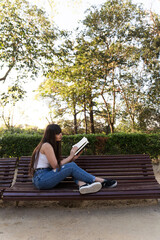 Young asian woman with a fringe reading a black book in the streets og Barcelona with natural sun light