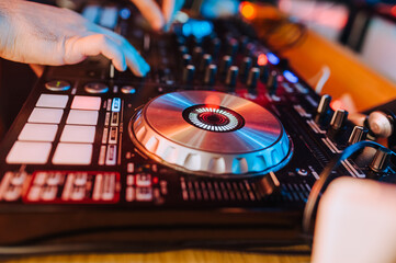 DJ professional plays music on the remote control in a nightclub. Photography, disco.
