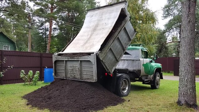 The dump truck unload soil to the ground. Dump truck unloading process.
