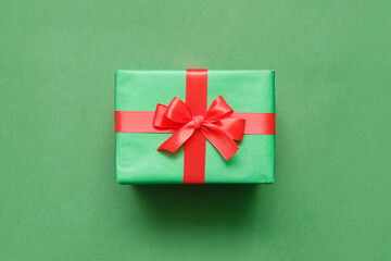 Christmas gift with red bow on green background