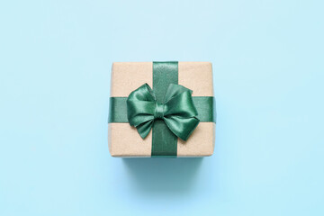 Christmas gift box with green bow on blue background