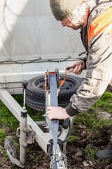 A man turns the trailer winch on a trailer, moving the load. Transportation and movement of vehicles.