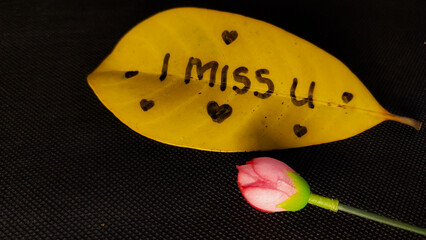 The word i miss you on dry leaves - Powered by Adobe