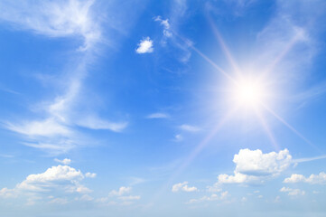 Obraz na płótnie Canvas blue summer sky with fluffy clouds and bright sun as a background.