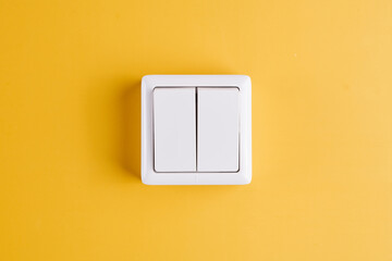 White double light switch isolated on yellow background. On/Off