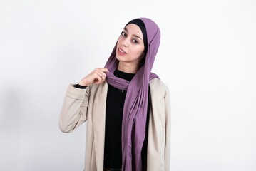 young beautiful muslim woman wearing hijab and jacket over white background stressed, anxious, tired and frustrated, pulling shirt neck, looking frustrated with problem