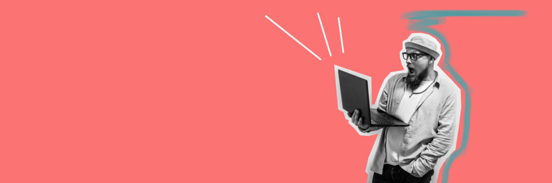 Young crazy bearded charismatic man. Shocked or surprised expression. Laptop concept. Funny promotion poster. Programmer, web developer holding a laptop in his hands and looking at the camera