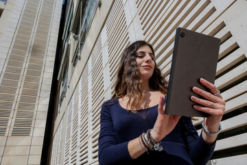 Manager donna tiene in mano il proprio tablet  in contesto urbano moderno