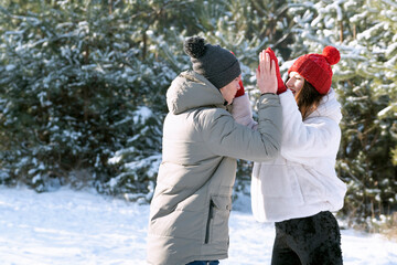 Happy guy and girl have fun and plays outdoors in winter. Winter holidays. Snowy sunny day