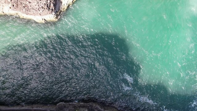 Crawton Waterfall (cascade), Aberdeenshire, Scotlland by drone (aerial view) situated on the Aberdeenshire coast, former fishing village now occupied by seabirds (kittiwakes, razorbills).