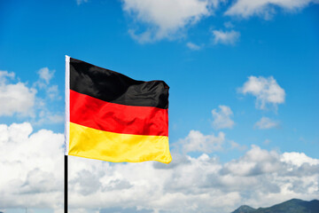 German flag waving against blue sky