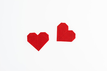 Red origami hearts on white background