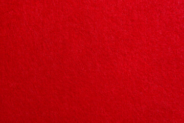 Red texture velour or felt cloth close-up. Natural or artificial sewing material. Fabric as...