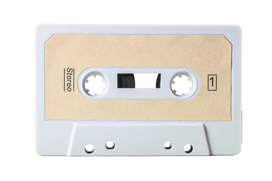 An Old Isolated Vintage Cassette Tape, Obsolete Music Tech From The 1980s. Dirty Ice Color Plastic Body, Pale Brown Sand Label With The Text Stereo And The Number One.
