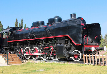 Fototapeta na wymiar Vintage rare black steam locomotive with red decorative trim