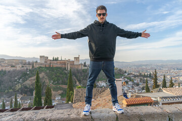 Man at the viewpoint of San Nicolas in Granada, wearing a black sweatshirt.