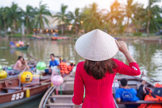 happy woman wearing Ao Dai Vietnamese dress, traveler visit Thu Bon River and Sightseeing Boat Ride at Hoi An ancient town. landmark for tourist attractions.Vietnam and Southeast travel concept