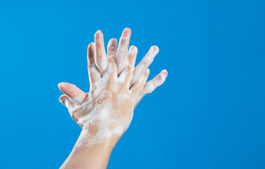 Woman rubbing fingers on blue background
