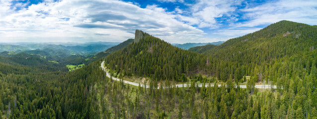 Winding track is like slopes of Rhodope Mountains with forests. Panorama, top view