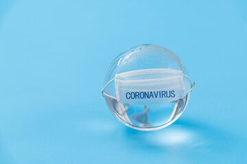 Earth globe with medical mask on blue background