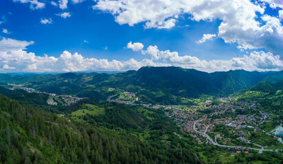 Obraz premium Bulgarian town Smolyan with lake, vegetation and clouds. Rhodope Mountains. Panorama, top view