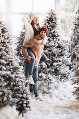 A couple stay on the snow in the Christmas forest