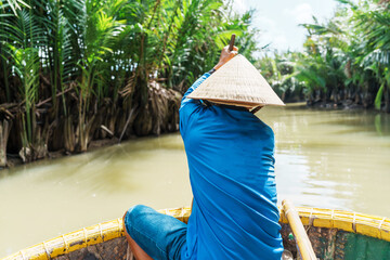 Man rowing a basket boat, along the coconut river forest, a unique Vietnamese at Cam thanh village....