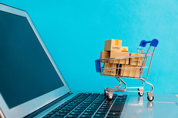 Shopping cart with boxes on laptop keyboard © xy