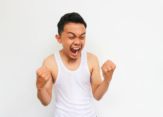 Excited man. happy and excited man wearing undershirt doing winner gesture with arms raised, smiling and screaming for success.