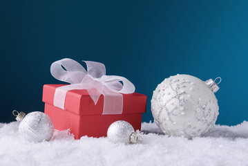 Gift box and Christmas balls over blue background with copy space. Christmas and New Year greeting...