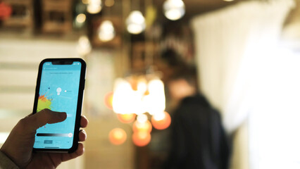 A man uses an application on his phone to change the color of electrical devices in the interior