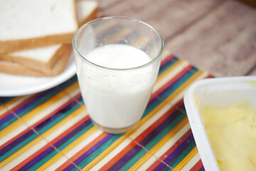 Close up of glass of milk and spoon on table 