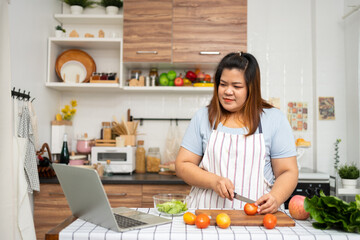 Asian Pregnant learn how to cook healthy meals from the Internet in kitchen, Fat women prepare a vegetable salad for diet food and lose weight. Concept of healthy eating