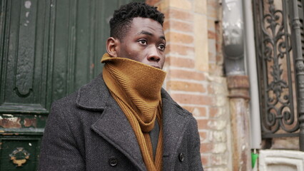 Young black man stepping outside during winter season. African person leaving house starting the day