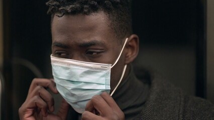 Young black African man wearing covid-19 face mask while commuting metro subway2