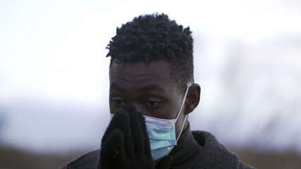 Young black man putting covid-19 face mask pandemic prevention
