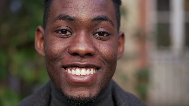 Young black African man standing smiling at camera, charismatic friendly person